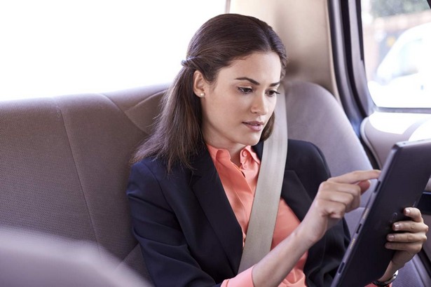 Woman in Taxi Using Tablet