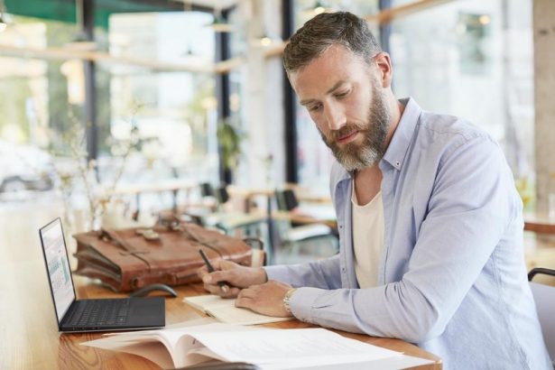 Two Men with Notebook in Cafe